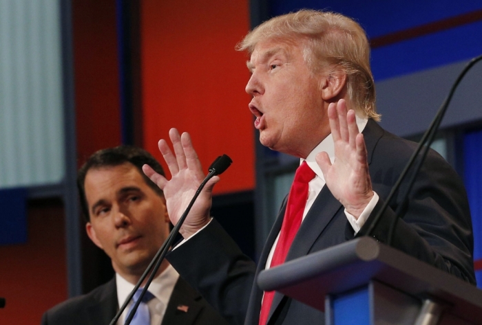 2016 U.S. Republican presidential candidate businessman Donald Trump answers a question as fellow candidate Wisconsin Governor Scott Walker (L) listens at the first official Republican presidential candidates debate of the 2016 U.S. presidential campaign in Cleveland, Ohio, August 6, 2015.