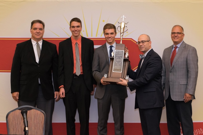 Russ Faubert, Senior Bible Quizzing Promotions Experienced Division Quizmaster, presents the first place trophy to the Experienced Division championship team from Grand Prairie, Texas, at the North American Bible Quiz Tournament in Oklahoma City, Oklahoma, on August 5, 2015.