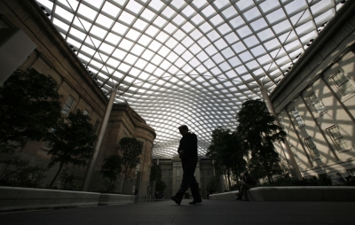 A visitor walks beneath the glass canopy designed by renowned architects Foster Partners in the courtyard between the Smithsonian's National Portrait Gallery and the Smithsonian American Art Museum in Washington, November 20, 2007. The renovated space, with its new roof, was opened to the public this week.