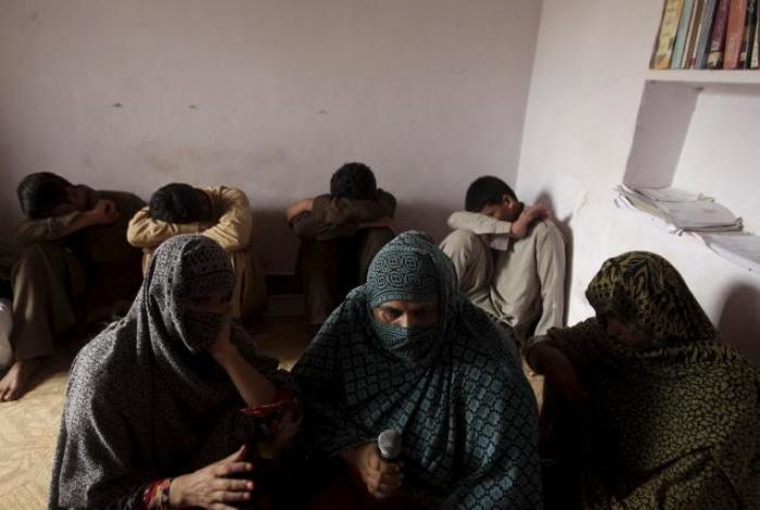 Children whose families say they have been abused, hide their faces while their mothers are interviewed by a Reuters correspondent in their village of Husain Khan Wala, Punjab province, Pakistan, August 9, 2015.