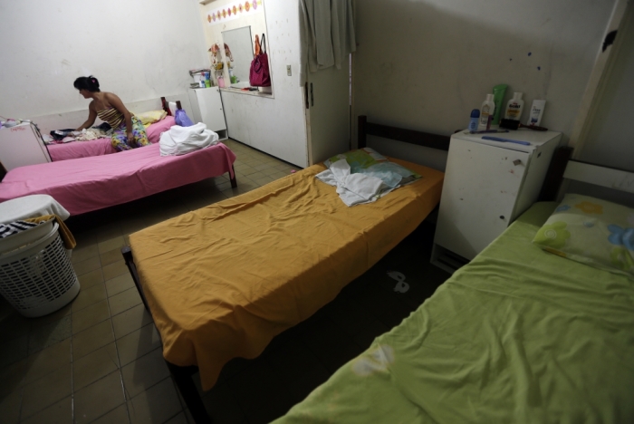 Jessica, 16, who was arrested by the police during a raid at a sex club, sits on her bed at a shelter for girls who have faced sexual violence or sexual commercial exploitation in Fortaleza, November 1, 2013.