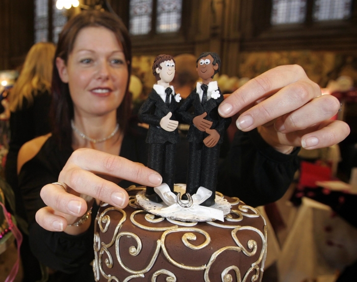 Jenny Taylor adjusts a wedding cake figurine of a couple made up of two men at the gay wedding show at the Town Hall in Manchester, November 6, 2005.