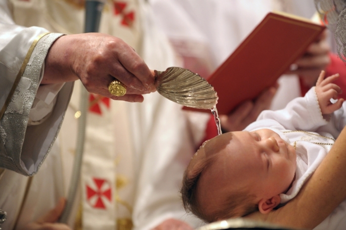 Pope Benedict XVI baptises a baby during a mass in the Sistine Chapel at the Vatican, Rome, Italy, January 10, 2010.