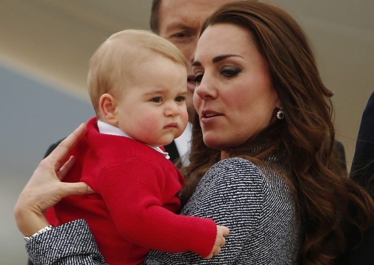 Britain's Catherine, the Duchess of Cambridge, holds her son Prince George as they prepare to board a plane with her husband, Prince William (not pictured), to depart Canberra, April 25, 2014.