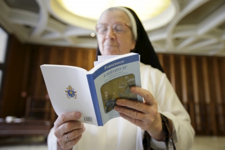 A nun reads Pope Francis' new encyclical titled 