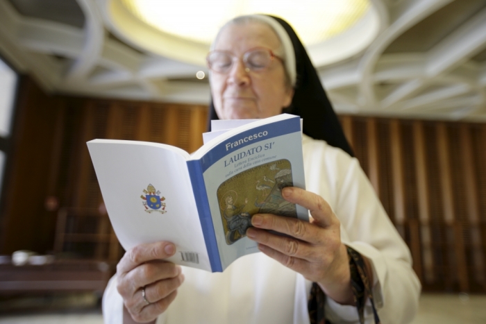 A nun reads Pope Francis' new encyclical titled 'Laudato si' at the Vatican, June 18, 2015. Pope Francis demanded swift action on Thursday to save the planet from environmental ruin, urging world leaders to hear 'the cry of the earth and the cry of the poor,' plunging the Catholic Church into political controversy over climate change. In the first papal document dedicated to the environment, he calls for 'decisive action, here and now,' to stop environmental degradation and global warming, squarely backing scientists who say it is mostly man-made.
