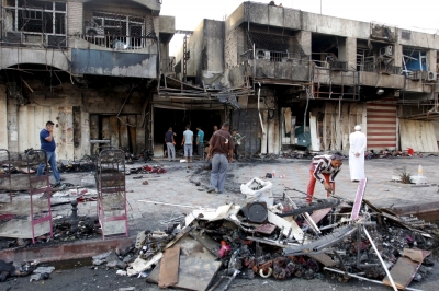 People gather at the site of car bomb in New Baghdad, July 22, 2015. Iraqi security forces and Sunni tribal fighters launched an offensive on Tuesday to dislodge Islamic State militants and secure a supply route in Anbar province, police and tribal sources said. As well as the bombing in New Baghdad, two others were killed in bomb attacks in Zafaraniya, the predominantly Shiite southern district of the capital.