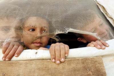 Syrian refugee children look out from their tent during a visit by United Nations (U.N.) Humanitarian Chief and Emergency Relief Coordinator Stephen O'Brien to their makeshift settlement in Saadnayel in Lebanon's Bekaa Valley August 17, 2015.
