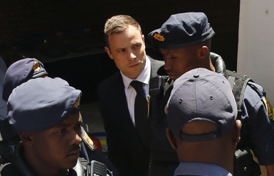 South African Olympic and Paralympic sprinter Oscar Pistorius (C) is escorted to a police van after his sentencing at the North Gauteng High Court in Pretoria October 21, 2014. Pistorius was sentenced to five years in prison on Tuesday for killing his girlfriend Reeva Steenkamp, ending a trial that has gripped South Africa and the world.