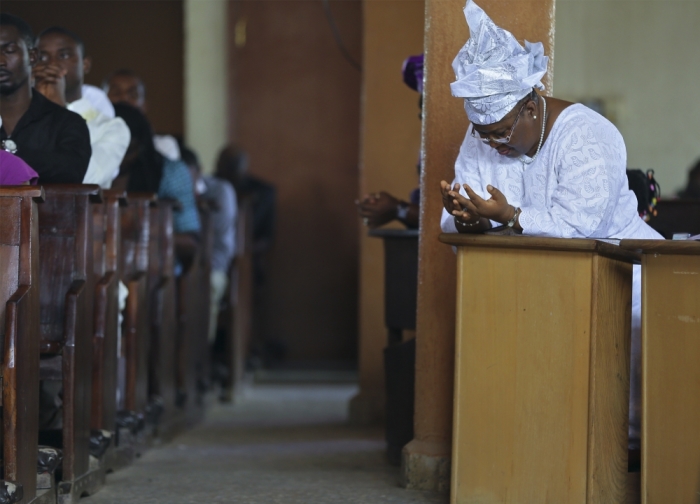 A woman prays during a New Year's day service at the Holy Rosary Catholic Church in Abuja, January 1, 2014.