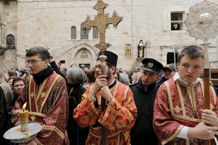 Members of the Greek Orthodox clergy await the arrival of the Greek Orthodox Patriarch of Jerusalem Metropolitan Theophilos before the washing of the feet ceremony outside the Church of the Holy Sepulchre in Jerusalem's Old City, April 9, 2015, ahead of Orthodox Easter.