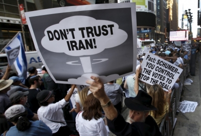 A man holds up a sign as he and several thousand other protesters demonstrate during a rally apposing the nuclear deal with Iran in Times Square, July 22, 2015.