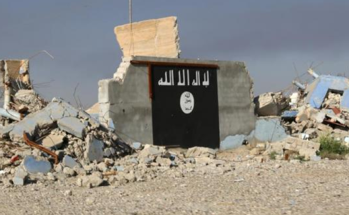 The ISIS flag is painted on a wall in the town of al-Alam