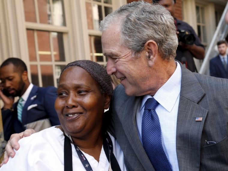 Former U.S. President George W. Bush hugs an employee of Warren Easton Charter High School one day before the ten year anniversary of Hurricane Katrina in New Orleans, Louisiana, August 28, 2015.