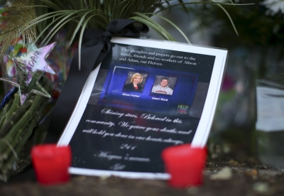 A picture of slain journalists Alison Parker and Adam Ward is seen next to candles at a memorial outside of the offices for WDBJ7 in Roanoke, Virginia August 27, 2015. Parker, 24, and Ward, 27, were shot dead on Wednesday during a live segment for the CBS affiliate in Roanoke, Virginia, at a local recreation site about 200 miles (320 km) southwest of Washington. Another woman was wounded. The suspected gunman, 41-year-old Vester Flanagan, later died from a self-inflicted gunshot wound, authorities said.