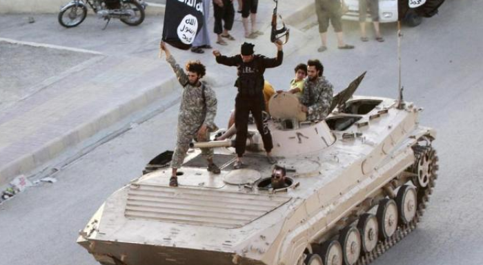 ISIS fighters participate in a street parade in Raqqa on June 30, 2014.