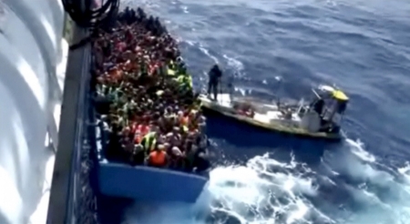 A boat full of migrants is seen next to Swedish ship Poseidon during a rescue operation in the sea off the coast of Libya in this still image taken from an August 26, 2015 video. Some 50 migrants were found dead in the hold of the boat on Wednesday during the rescue operation which saved 430 other people, the Italian coast guard said.