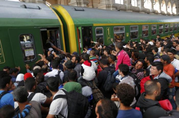 Migrants storm into a train at the Keleti train station in Budapest, Hungary, September 3, 2015 as Hungarian police withdrew from the gates after two days of blocking their entry.