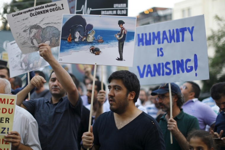 People hold posters with drawings depicting a drowned Syrian toddler during a demonstration for refugee rights in Istanbul, Turkey, September 3, 2015. The distraught father of two Syrian toddlers who drowned with their mother and several other migrants as they tried to reach Greece identified their bodies on Thursday and prepared to take them back to their home town of Kobani. Abdullah Kurdi collapsed in tears after emerging from a morgue in the city of Mugla near Bodrum, where the body of his three-year old son Aylan washed up on Wednesday. The image of Aylan, drowned off one of Turkey's most popular holiday resorts, went viral on social media and piled pressure on European leaders. Abdullah's family had been trying to emigrate to Canada after fleeing the war-torn town of Kobani, a revelation which also put Canada's Conservative government under fire from its political opponents.