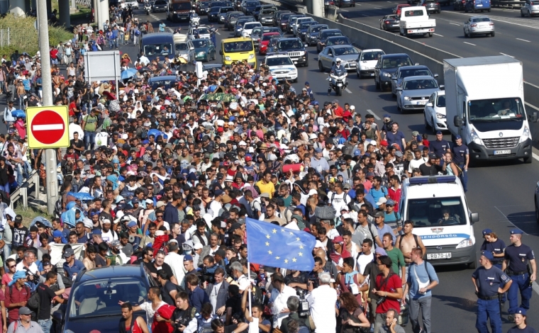 Migrants march along the highway towards the border with Austria, out of Budapest, Hungary, September 4, 2015. Hundreds of migrants broke out of a Hungarian border camp on Friday and others set off on foot from Budapest as authorities scrambled to contain a migrant crisis that has brought Europe's asylum system to breaking point. Hungary says it is enforcing European Union rules that it must register all migrants caught crossing Hungary's borders, but thousands are refusing and demand they be allowed to continue their journey to western Europe from war and poverty in the Middle East, Africa and Asia. The European Union normally allows free movement between the 26 countries of its Schengen border-free zone, but its rules require asylum seekers to register in the first country where they arrive and remain until they are processed.