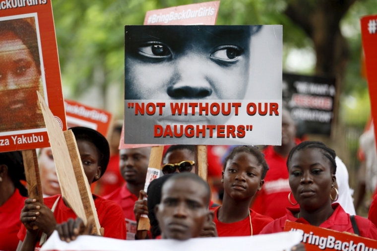 Bring Back Our Girls campaigners hold banners as they walk during a protest procession marking the 500th day since the abduction of girls in Chibok, along a road in Lagos August 27, 2015. The Islamist militant group Boko Haram kidnapped some 270 girls and women from a school in Chibok a year ago. More than 50 eventually escaped, but at least 200 remain in captivity, along with scores of other girls kidnapped before the Chibok girls.