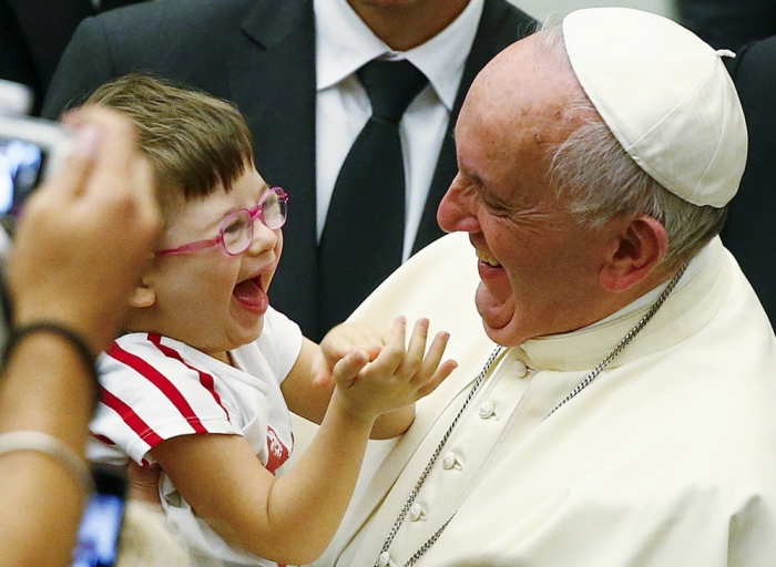 Pope Francis laughs with a baby during a special audience with parish cells for the evangelization in Paul VI hall at the Vatican, Rome, Italy, September 5, 2015.