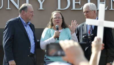 Kim Davis, flanked by Republic presidential candidate Mike Huckabee (L) and and Attorney Mathew Staver (R) speaks to her supporters after walking out of jail in Grayson, Kentucky September 8, 2015. U.S. District Judge David Bunning ordered her release after six days in jail, saying she 'shall not interfere in any way, directly or indirectly, with the efforts of her deputy clerks to issue marriage licenses to all legally eligible couples.'
