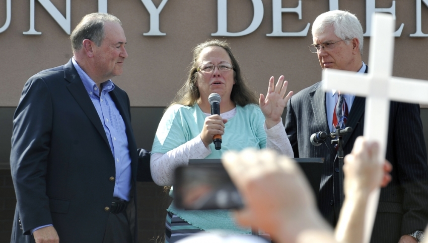 Kim Davis, flanked by Republic presidential candidate Mike Huckabee (L) and and Attorney Mathew Staver (R) speaks to her supporters after walking out of jail in Grayson, Kentucky September 8, 2015. U.S. District Judge David Bunning ordered her release after six days in jail, saying she "shall not interfere in any way, directly or indirectly, with the efforts of her deputy clerks to issue marriage licenses to all legally eligible couples."