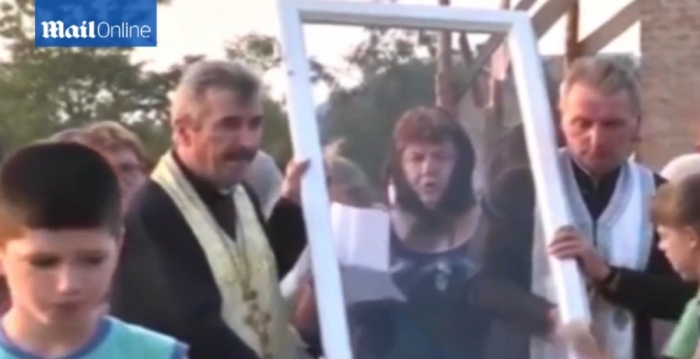 Church elders can be seen carrying the window allegedly depicting the images of Mary and Jesus from the house to be displayed at the village church in Ukraine in this September 2015 story.