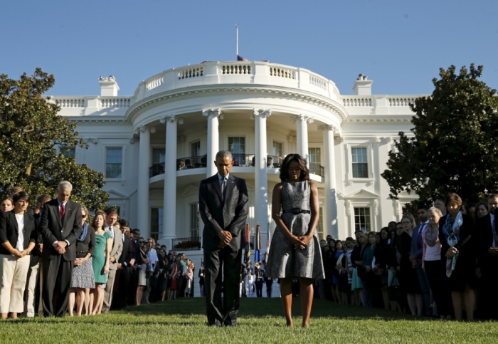 U.S. President Barack Obama and first lady Michelle Obama observe a moment of silence on the South Lawn of the White House to mark the 14th anniversary of the 9/11 attacks, in Washington September 11, 2015.