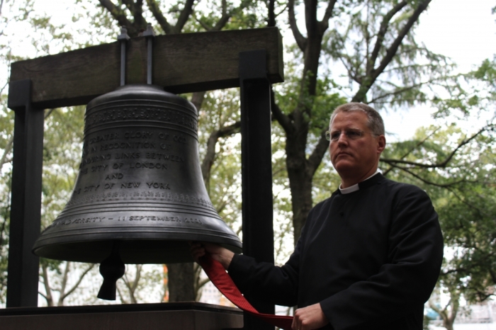 The Rev. William Lupfer, rector of Trinity Wall Street, rings the Bell of Hope in the churchyard of the historic St. Paul's Chapel which forms part of the Episcopal Parish of Trinity Wall Street in Lower Manhattan, New York City, on September 11, 2015.