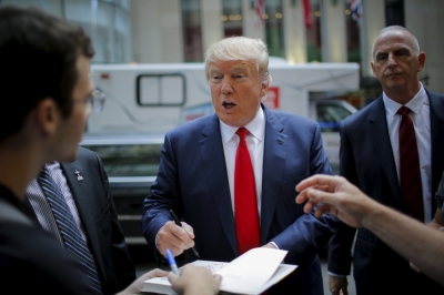 Republican presidential candidate Donald Trump signs autographs as he arrives to attend the Jimmy Fallon show in the Manhattan borough of New York, September 11, 2015.