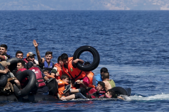 Syrian and Afghan refugees fall into the sea after their dinghy deflated some 100m away from the Greek island of Lesbos, September 13, 2015. Of the record total of 432,761 refugees and migrants making the perilous journey across the Mediterranean to Europe so far this year, an estimated 309,000 people had arrived by sea in Greece, the International Organization for Migration said on Friday. About half of those crossing the Mediterranean are Syrians fleeing civil war, according to the United Nations refugee agency.