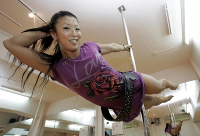 Pole dancing world champion Reiko Suemune strikes a pose for a photograph at her 'Luxurica' pole dancing studio in Tokyo June 9, 2007. Pole dancing is gaining popularity among Japanese women as a new form of exercise.