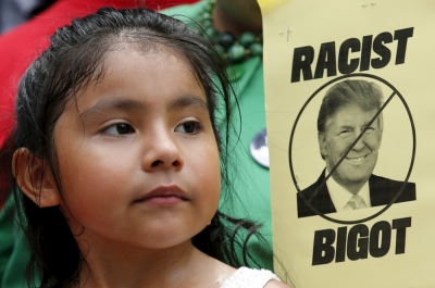 A girl participates in a protest calling for businesses to sever their relationships with U.S. Republican presidential candidate Donald Trump over his recent comments about Mexican immigrants as they demonstrate outside the site of a new hotel owned by Trump at the Old Post Office Building in Washington July 9, 2015.