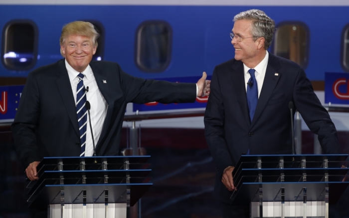 Republican U.S. presidential candidate and businessman Donald Trump (L) reaches out to pat former Florida Governor Jeb Bush on the back after Bush said he would want his Secret Service code name to be 'Energizer' during the second official Republican presidential candidates debate of the 2016 U.S. presidential campaign at the Ronald Reagan Presidential Library in Simi Valley, California, United States, September 16, 2015.