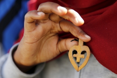 A Christian migrant from Eritrea shows a crucifix made of wood after she attended a Sunday mass at the makeshift church in 'The New Jungle' near Calais, France, August 2, 2015.