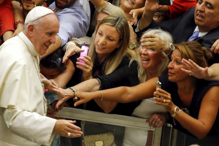 Faithful react as Pope Francis arrives to lead his weekly audience in Paul VI hall at the Vatican City, August 5, 2015.