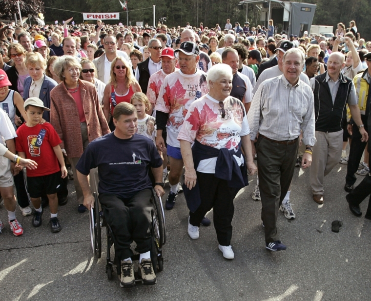 Canada's Prime Minister Paul Martin (R) walks with Betty Fox (2nd R), the mother of the late marathoner Terry, during the annual Terry Fox Run in Port Coquitlam, British Columbia, east of Vancouver, September 18, 2005. This year is the 25th anniversary of Terry's Marathon of Hope in which he attempted to run across Canada to raise money but was forced to stop after his cancer returned. Also taking part are Sheila Martin (2nd L), Martin's wife, Rick Hanson (wheelchair) and Premier Gordon Campbell (C back). Some 400 million dollars has been raised for cancer research since the annual walks, held around the world, were started following Terry's death in 1981.