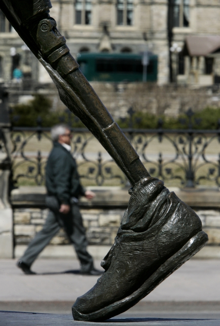 A man walks past the statue honoring runner Terry Fox on the 25th anniversary of the start of his marathon across Canada for cancer research, in Ottawa, April 12, 2005. Fox, who lost his leg to bone cancer, ran 5,373 kilometers over 143 days using a prosthetic leg before the recurrence of cancer eventually killed him.