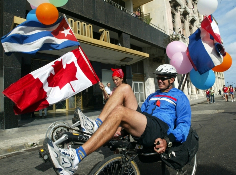 A father and his daughter ride through Prado Boulevard while participating in the 7th Terry Fox Marathon of Hope, in Havana February 8, 2004. The marathon is held annually to raise funds for cancer research and to honor Canadian Terry Fox, who was diagnosed with cancer at the age of 18 in 1977. With his right leg partially amputated, Fox started to run a marathon every day across Canada, completing 5,373 km, until he was forced to stop as the cancer had spread to his lungs. Fox died at the age of 22.