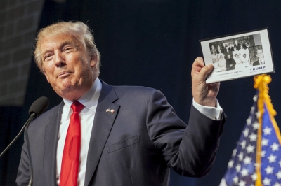 U.S. Republican presidential candidate Donald Trump holds his baptism photo while speaking at the Iowa Faith and Freedom Coalition Forum in Des Moines, Iowa, September 19, 2015.