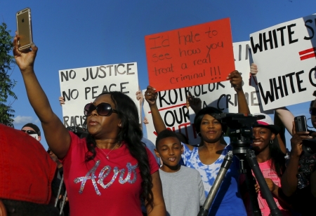 Protesters rally during a protest against what demonstrators call police brutality in McKinney, Texas June 8, 2015. Hundreds marched through the Dallas-area city of McKinney on Monday calling for the firing of police officer Eric Casebolt, seen in a video throwing a bikini-clad teenage girl to the ground and pointing his pistol at other youths at a pool party disturbance.