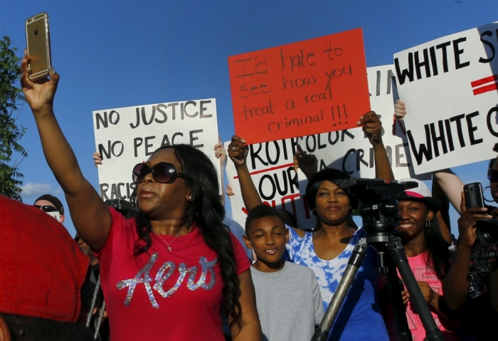 Protesters rally during a protest against what demonstrators call police brutality in McKinney, Texas June 8, 2015. Hundreds marched through the Dallas-area city of McKinney on Monday calling for the firing of police officer Eric Casebolt, seen in a video throwing a bikini-clad teenage girl to the ground and pointing his pistol at other youths at a pool party disturbance.