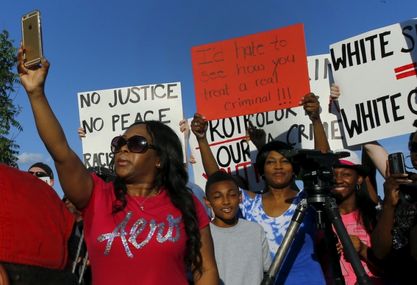 Protesters rally during a protest against what demonstrators call police brutality in McKinney, Texas June 8, 2015. Hundreds marched through the Dallas-area city of McKinney on Monday calling for the firing of police officer Eric Casebolt, seen in a video throwing a bikini-clad teenage girl to the ground and pointing his pistol at other youths at a pool party disturbance.