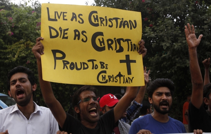 A member of the Pakistani Christian community holds a placard as he shouts slogans during a protest rally to condemn Sunday's suicide attack in Peshawar on a church, with others in Lahore September 23, 2013. A pair of suicide bombers blew themselves up outside the 130-year-old Anglican church in Pakistan after Sunday mass, killing at least 78 people in the deadliest attack on Christians in the predominantly Muslim country.
