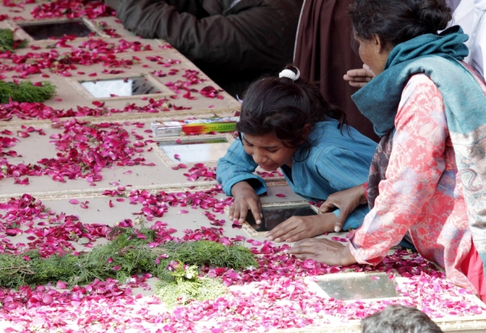 A girl from the Christian community mourns over the coffin of her brother, who was one of the victims killed by a suicide attack on a church, during his funeral in Lahore, Pakistan, March 17, 2015. Suicide bombings outside two churches in Lahore killed 14 people and wounded nearly 80 others during services on Sunday in attacks claimed by a faction of the Pakistani Taliban.