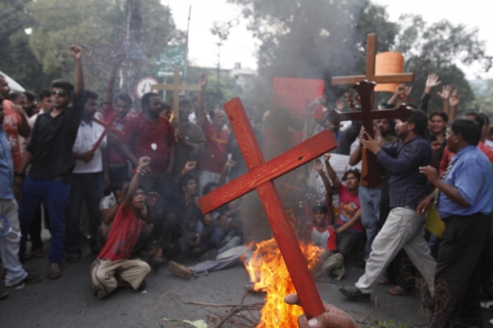 Members of the Pakistani Christian community hold crosses in front of a fire during a protest rally to condemn Sunday's suicide attack in Peshawar on a church, with others in Lahore September 23, 2013. A pair of suicide bombers blew themselves up outside the 130-year-old Anglican church in Pakistan after Sunday mass, killing at least 78 people in the deadliest attack on Christians in the predominantly Muslim country.