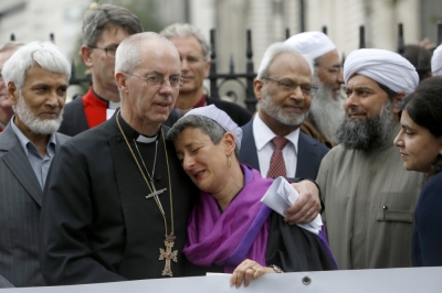 The Archbishop of Canterbury, Justin Welby (2L), Senior Rabbi Laura Janner-Klausner (C), Imam Shaykh Ibrahim Mogra (2R) and Sayeeda Warsi (R) react together at the close of a vigil outside Westminster Abbey in central London September 3, 2014. Religious leaders attended the vigil to unite against human rights violations in Iraq.