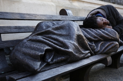 A man sleeps on a sculpture of a figure called 'Homeless Jesus' in front of the Archdiocese of Washington Catholic Charities offices in Washington, September 16, 2015. During Pope Francis' visit to the U.S., which begins September 22, 2015, the pope will highlight the work of the Archdiocese of Washington Catholic Charities, who help more than 100,000 clients annually with services including food distribution, medical and dental care, and legal services. Picture taken September 16, 2015.